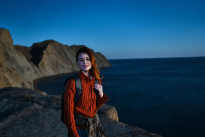 Young woman standing in sea against clear blue sky