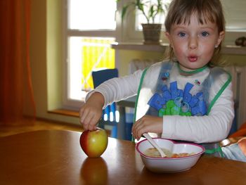 Portrait of cute girl having breakfast at table