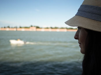 Side view of young woman against sea