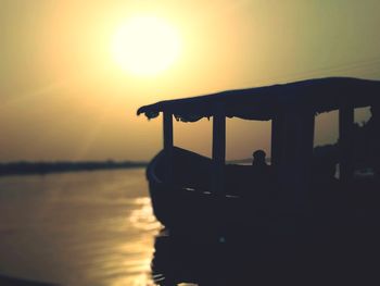 Silhouette boat in sea against sky during sunset