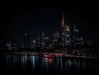 Illuminated buildings against sky at night