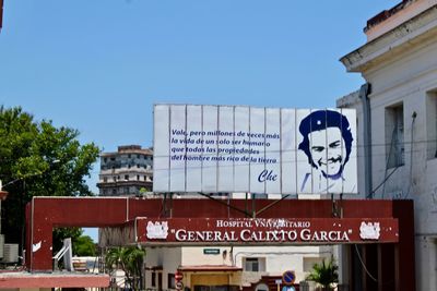 Information sign on building against clear blue sky