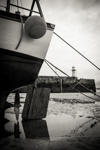 Boat moored at beach against sky