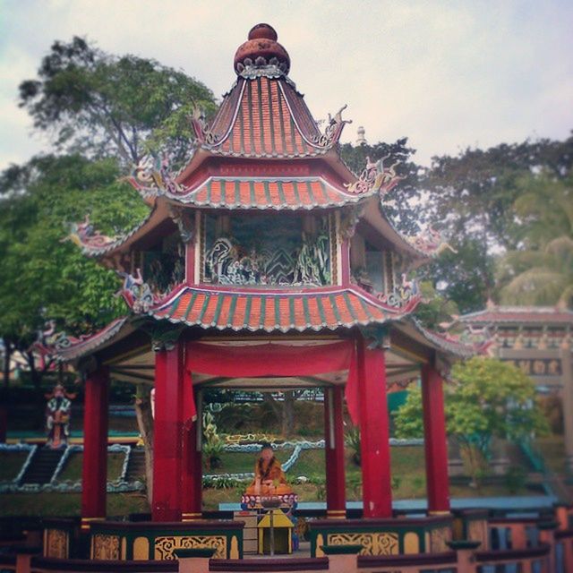 place of worship, religion, spirituality, temple - building, architecture, built structure, building exterior, temple, tree, tradition, statue, pagoda, cultures, low angle view, sky, roof, art and craft, sculpture, art