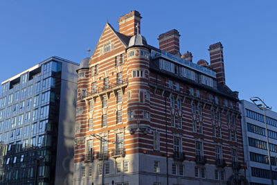 Low angle view of buildings against clear blue sky