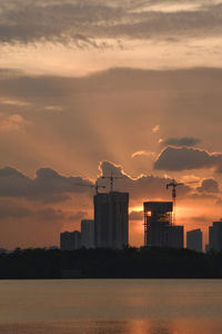 Buildings in city against sky during sunset