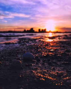 Close-up of water on beach against sky during sunset