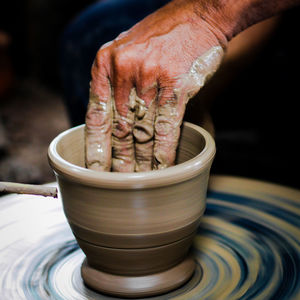 Close-up of person making pot