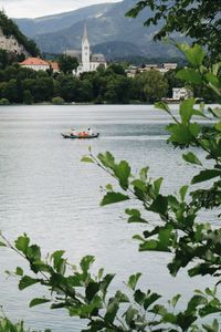 Scenic view of river by building against trees