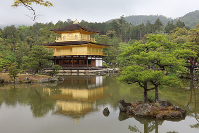 Gazebo by lake against trees