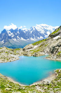 Scenic view of lake and mountains against blue sky