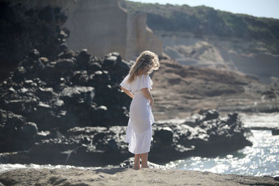 Woman standing on rock at beach