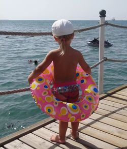 Rear view of girl standing on sea shore