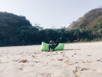 Lounge chairs on beach against clear sky