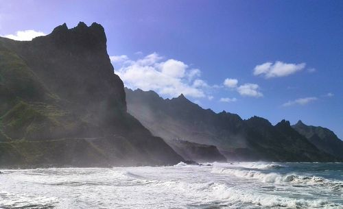 Scenic view of sea and mountains against sky