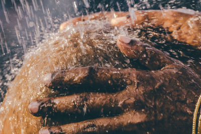 Cropped hands taking shower