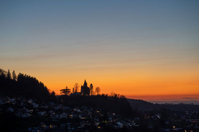 Silhouette buildings against sky during sunset