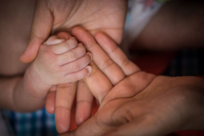 Midsection of father holding baby hand