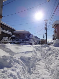 Snow covered houses and buildings against sky