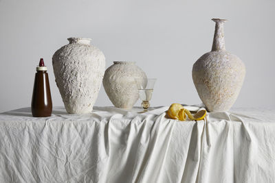 Close-up of white flowers on table against wall