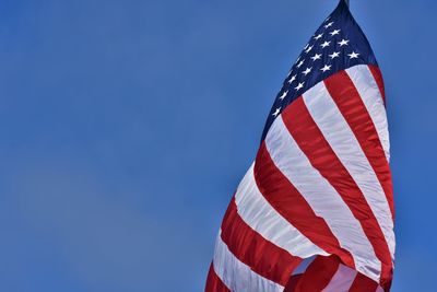 Low angle view of flag against clear blue sky