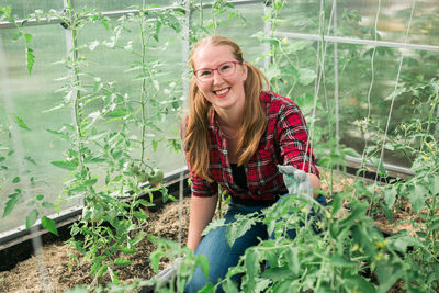 Young woman standing amidst plants