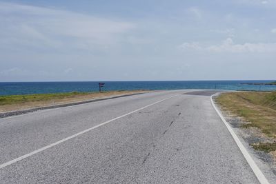 Road by sea against sky