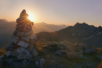Stack of rocks against sky during sunset