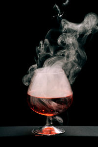 Close-up of beer glass against black background