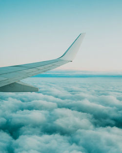 Airplane flying over cloudscape against sky