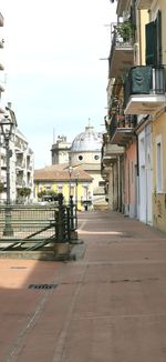 Street amidst buildings in town against sky