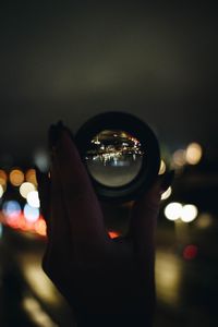 Close-up of hand holding lens at night