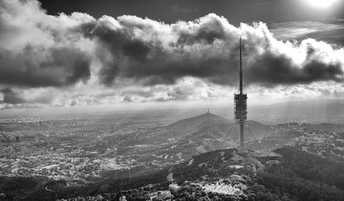 High angle view of torre de collserola on tibidabo hill against cloudy sky