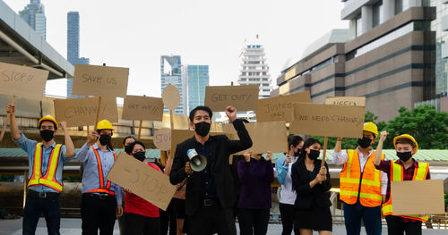 People standing on street against buildings in city