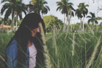 Young woman standing in long gras