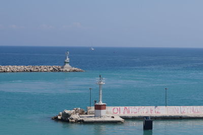 Lighthouse by sea against sky