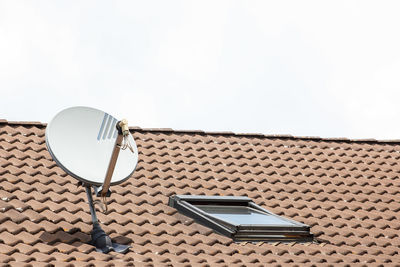 Satellite dish on a red tile roof