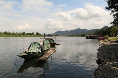 Boat moored in river against sky