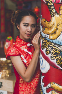 Portrait of smiling young woman standing by decorations