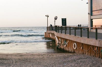 Pier on beach against clear sky