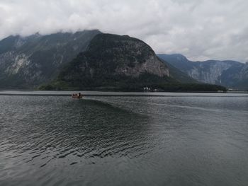 Scenic view of lake by mountains against sky