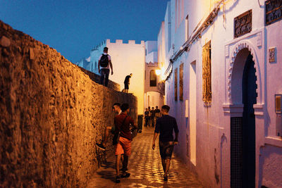 People walking on street amidst buildings in city