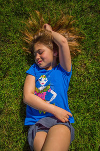 High angle view of teenage girl lying on grassy field