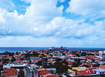 High angle view of townscape by sea against sky