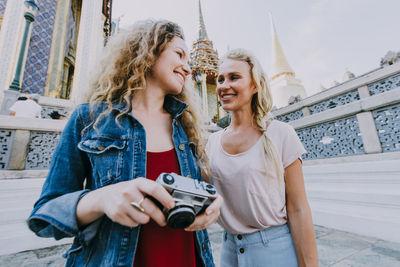 Portrait of a smiling young woman using mobile phone