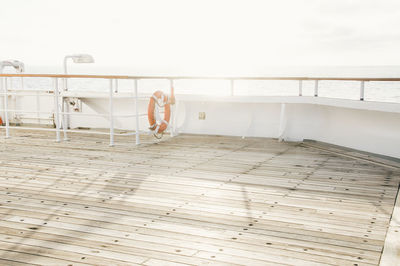 Empty boat deck with railings against clear sea