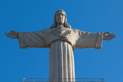 Low angle view of statue against blue sky