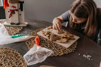 High angle view of girl decorating a cookie