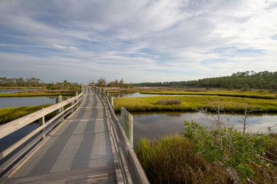 Empty pathway bridge over coastal landscape