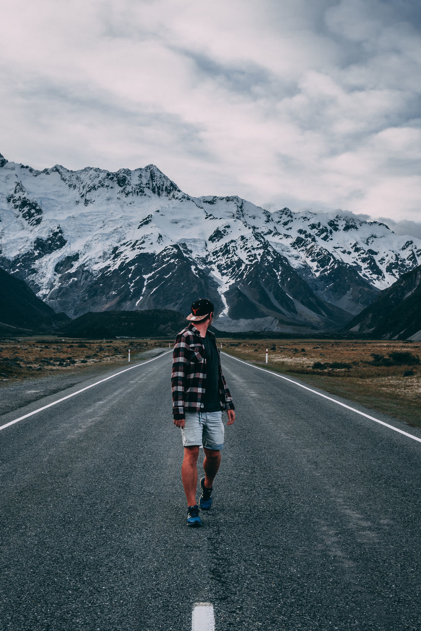 mountain, full length, snow, sky, one person, road, real people, winter, beauty in nature, scenics - nature, mountain range, leisure activity, cloud - sky, lifestyles, cold temperature, transportation, snowcapped mountain, nature, outdoors